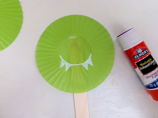 Glue jumbo craft stick to the back of the front cupcake liner.